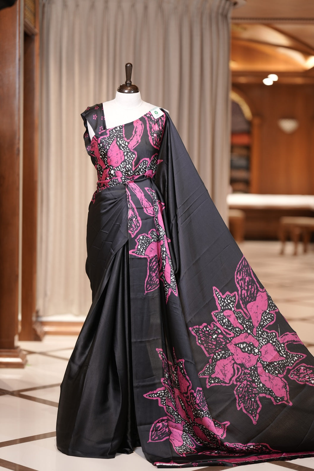 Black colour modal satin saree featuring soft satin touch fabric with bold Magenta colour floral prints across the body and matching pallu & Comes with a coordinated floral printed blouse for a chic, graceful look