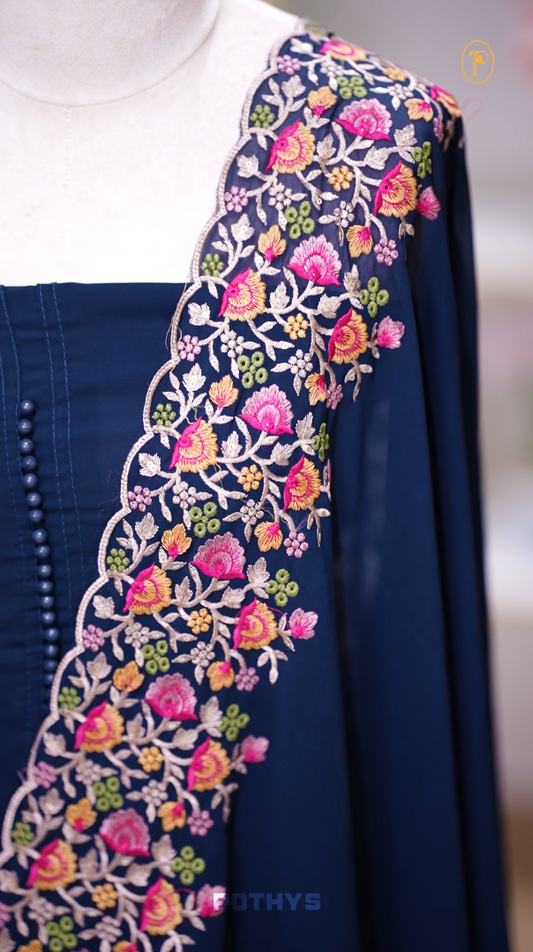 Navy blue colour Chiffon churidhar material featuring a plain top adorned with delicate beads work on the neckline, paired with a plain bottom, Highlighted by a dupatta with floral embroidery, sequins, and scalloped edges.