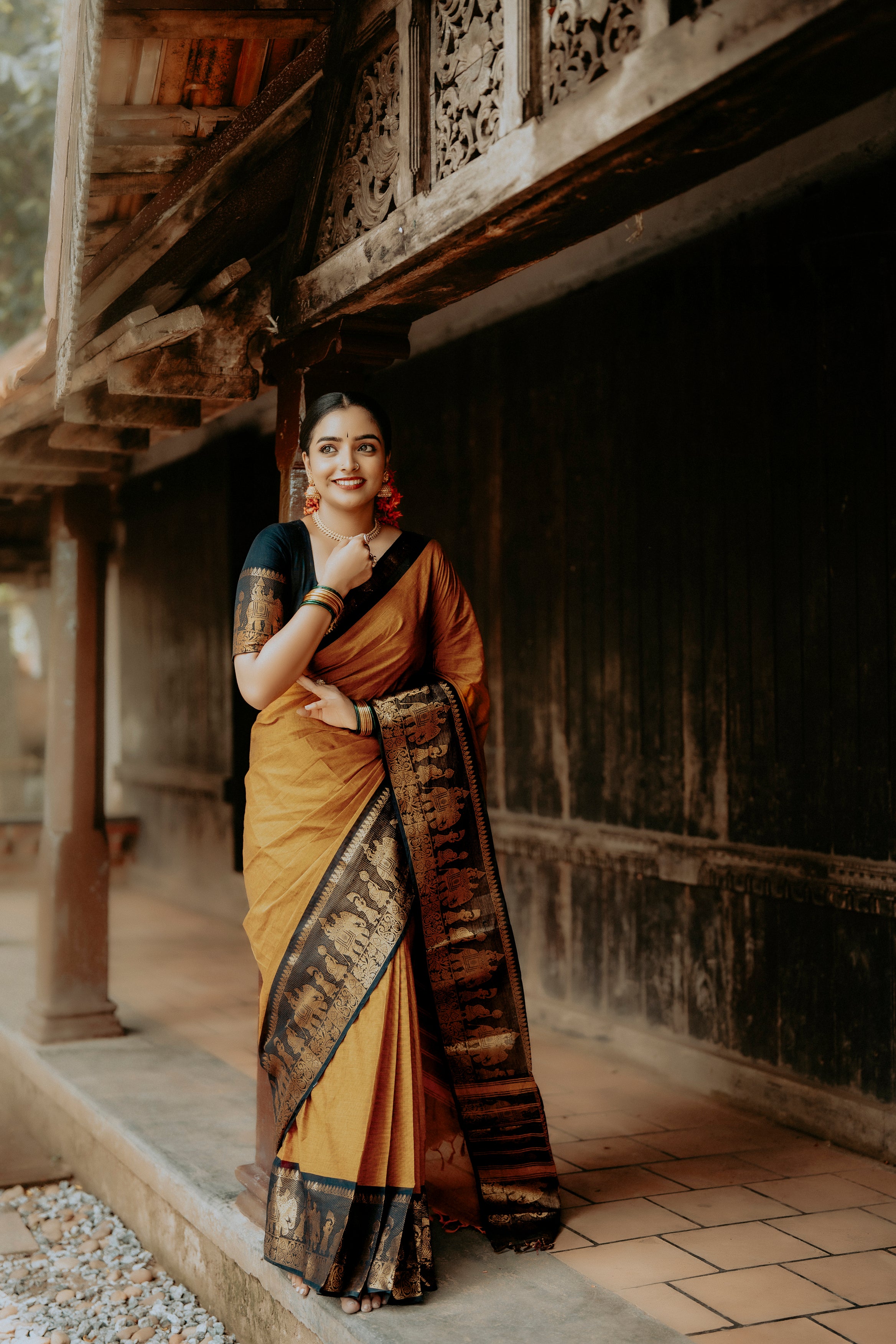 Mustard colour chettinad cotton saree with Elegant plain body, complemented by Contrast Black colour with Gold zari  border, paired with matching blouse piece.