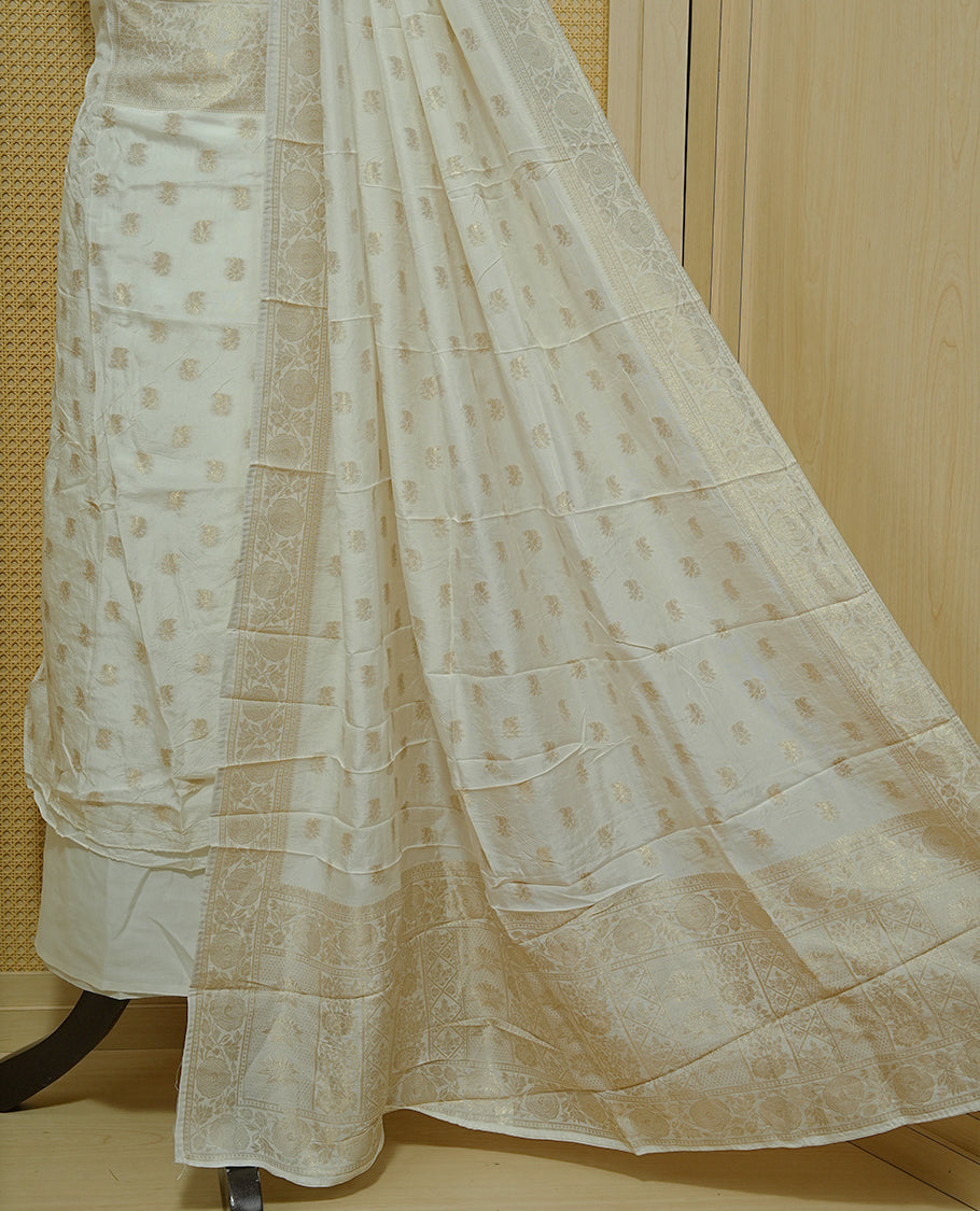 Cream colour Salwar material featuring gold zari Buttas on body & zari worked Neck Portion, paired with matching dupatta & Bottom.