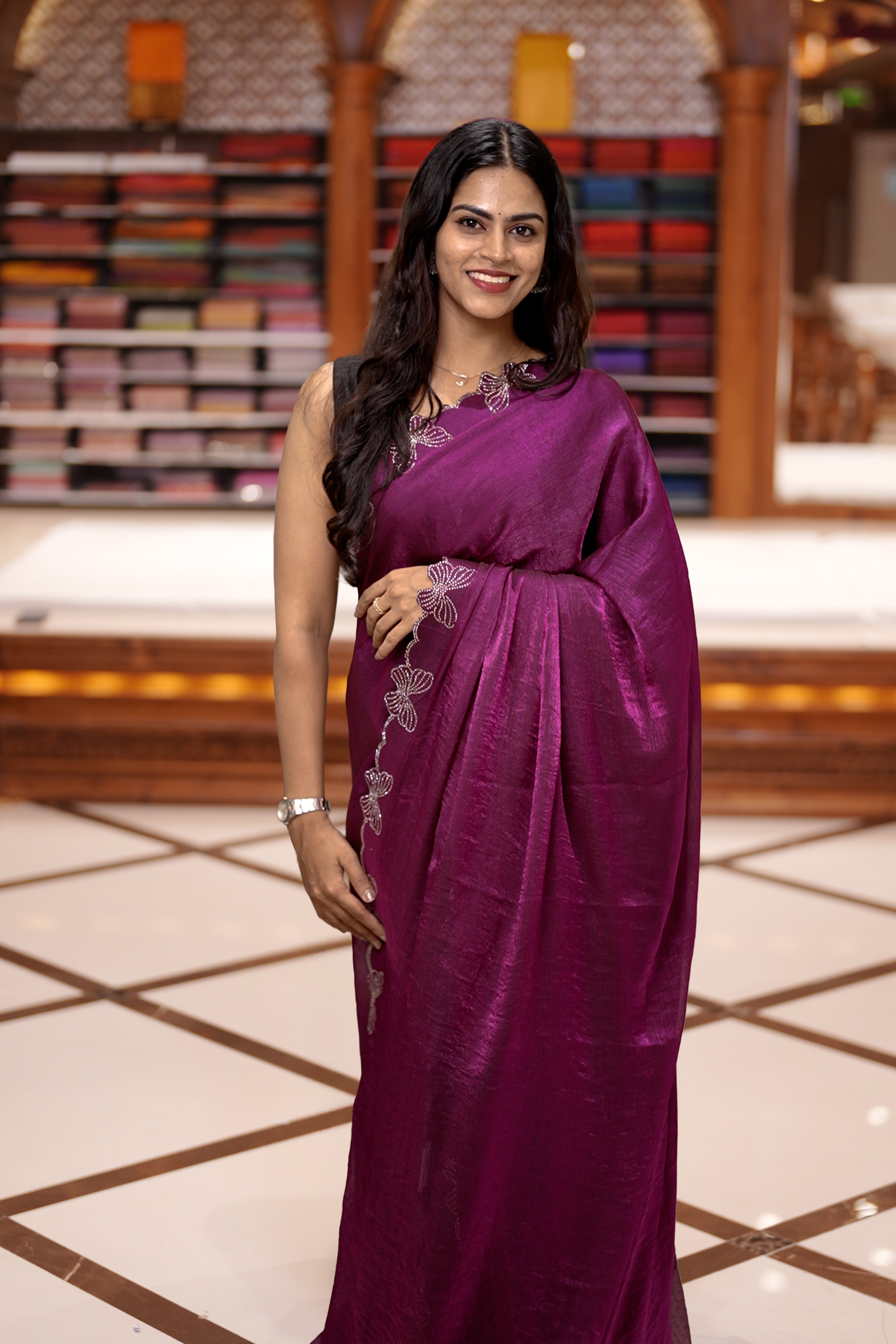 Purple colour chiffon saree adorned with Swarovski stone butterfly designs along the side border, adding a touch of sparkle, Paired with a matching blouse piece featuring the same intricate stone work.