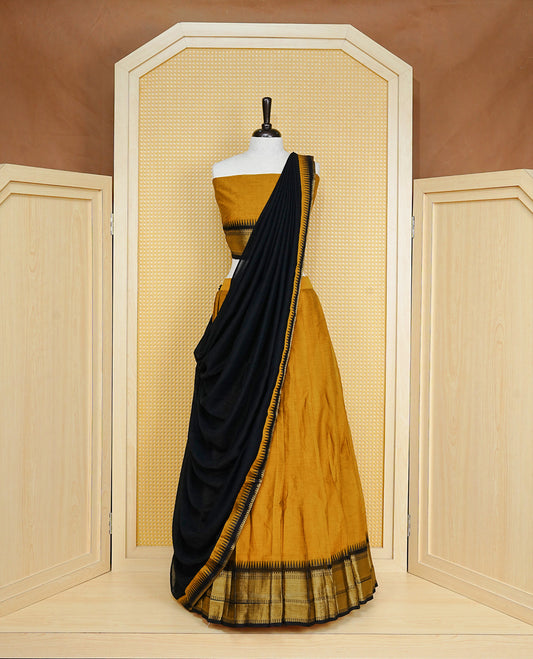 Mustard colour Semi Stitched Dhavni set Featuring Mustard Skirt With Contrast Black colour with Zari border, paired with UnStitched Blouse & Elegant Dupatta.