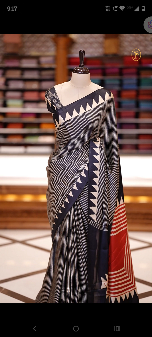 Black & Beige colour Turkey crepe saree featuring soft, flowy fabric with a rich texture, Designed with black and white stripes, bold triangular borders, and a red geometric pallu&  Comes with a matching blouse piece.