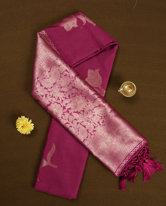Burgundy colour semi silk saree adorned with elegant floral motifs on the body, complemented by a shimmering golden zari-woven pallu and border, and paired with a matching blouse