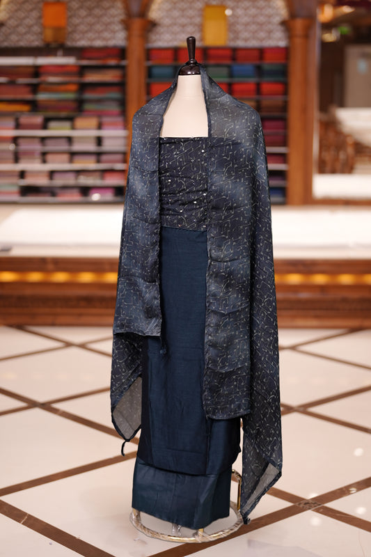 Blue colour semi silk salwar material featuring subtle mirror work on the top, paired with a plain matching bottom & The set is completed with chiffon dupatta adorned with golden abstract prints for a classy finish.