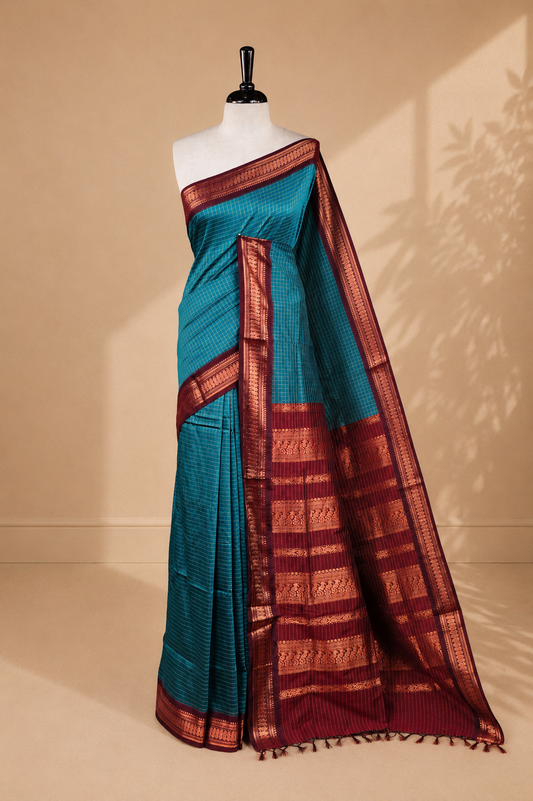 Blue colour kalyani cotton saree featuring antique zari motifs on body, complemented by Maroon colour with Antique zari border, paired with matching blouse piece.