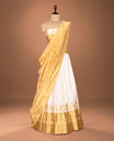 Off white colour Semi stitched dhavani set featuring Gold zari Buttas with Contrast gold colour border skirt, paired with matching blouse & dupatta.