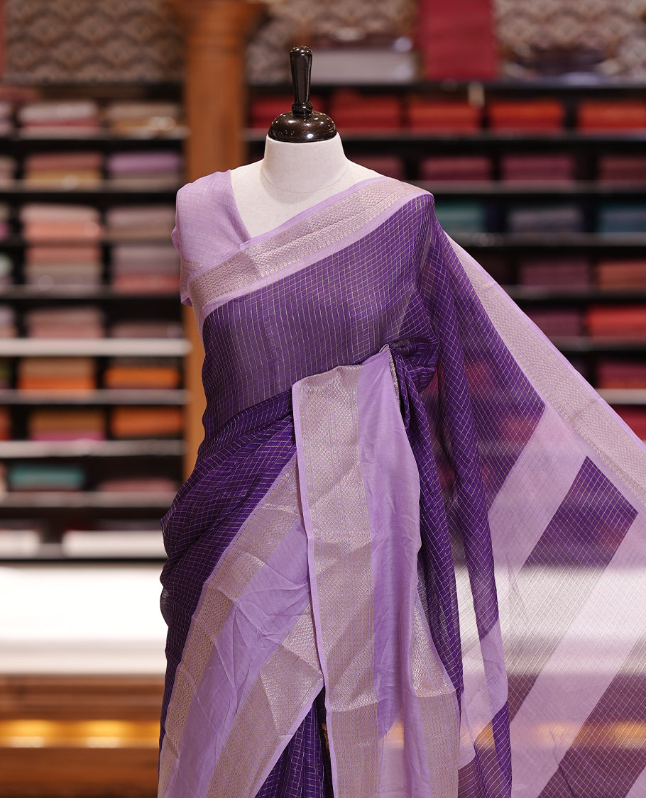 Royal purple colour saree featuring fine check patterns on the body, paired with a lavender zari woven border and pallu. Comes with a matching blouse piece