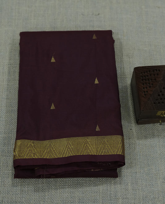 Maroon colour semi silk saree featuring subtle gold motifs and a finely woven zari border