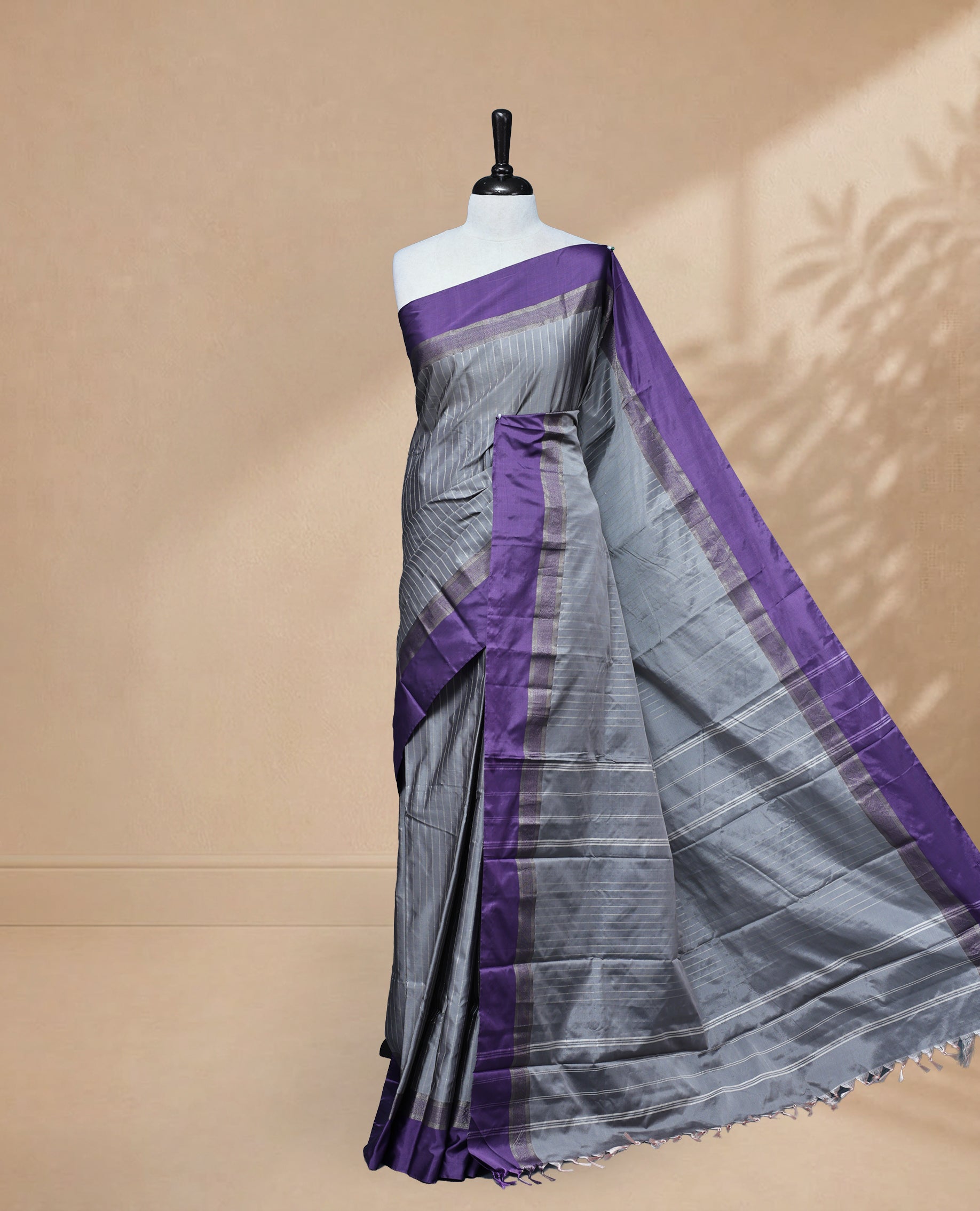 Grey colour Semi Silk Saree Featuring Gold zari Stripes on body, complemented by Contrast Border Detailing, comes with matching blouse piece.