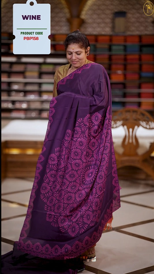 Dark purple colour Turkey crepe saree with an bigcircle fancy print on the pallu, stylish printed border, and matching blouse.