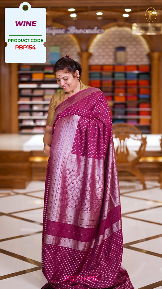 Wine colour Semi Banaras georgette saree adorned with delicate silver zari motifs and a rich woven pallu & Comes with a  matching  blouse.