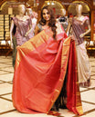 Graceful salmon pink colour Kancheepuram Samudrika Pattu Saree adorned with exclusive floral kolam concept jacquard and detailed Meenakari weaving, complemented by a classic traditional pure zari border and a matching blouse piece.